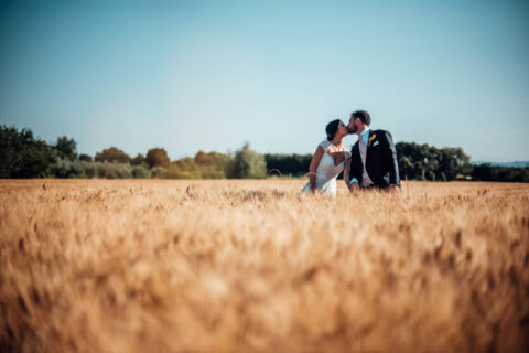Nico e Gioia nel campo di grano durante le fotografie di matrimonio
